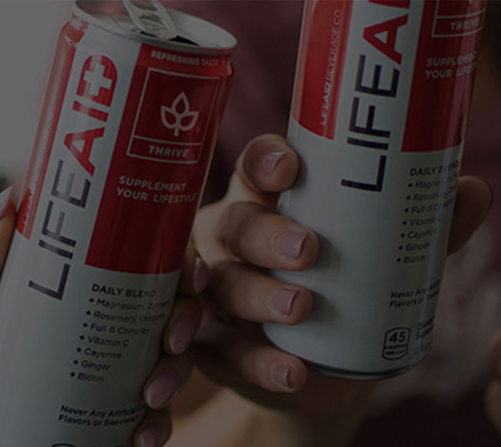 Two cans of LIFEAID, being held and grayed out, out of focus
