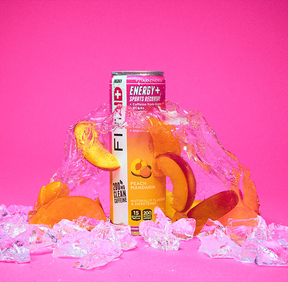 A can of FITAID Energy Peach Mandarin surrounded by peach and ice cubes.