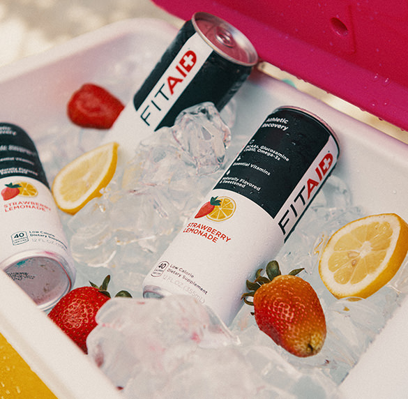 A can of FITAID Strawberry Lemonade surrounded by strawberries and lemons.