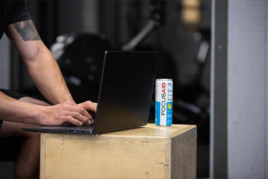A man working with laptop accompanied by can of FOCUSAID.