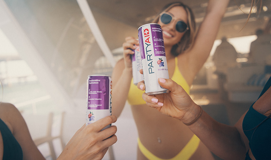 People partying while holding a can of PARTYAID.