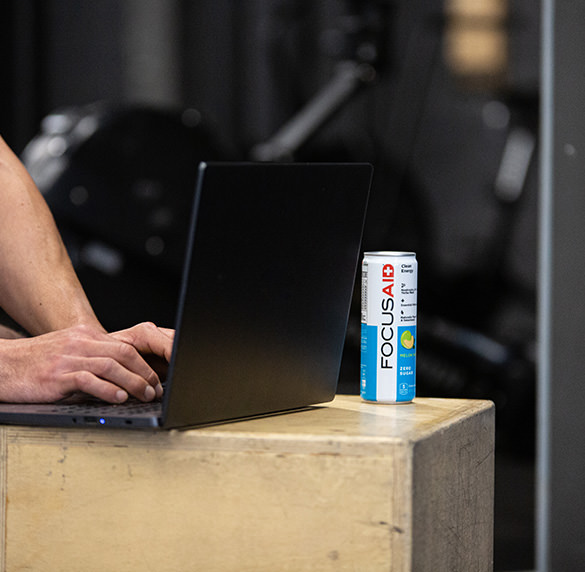 A man working with laptop accompanied by can of FOCUSAID.